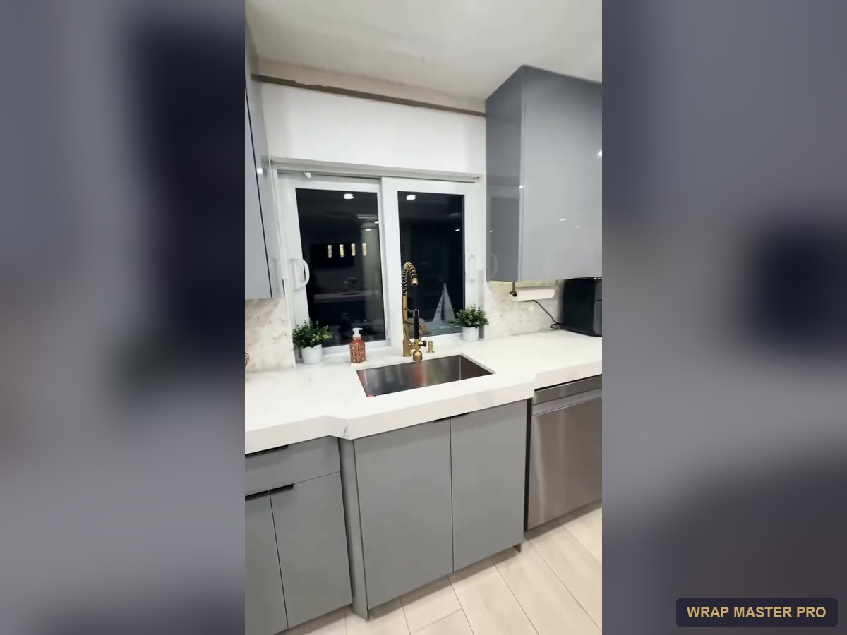 Gray high-gloss acrylic kitchen with a waterfall peninsula, South Florida