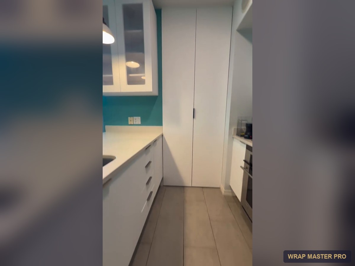 Bright white condo kitchen with an enclosed floor-to-ceiling pantry, South Florida